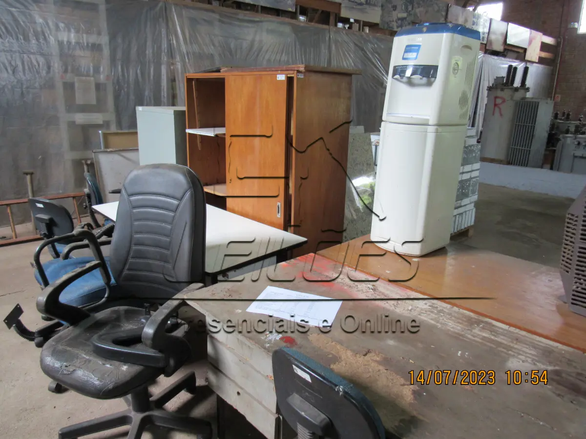 LOTE 005 - Bens diversos (03 mesa, 02 armários, 01 circulador de ar, 06 cadeira, 04 monitores para computador, 01 bebedouro, 01 motor movimentador portão, 02 suportes de cancelas e 366 tijolos de vidro)