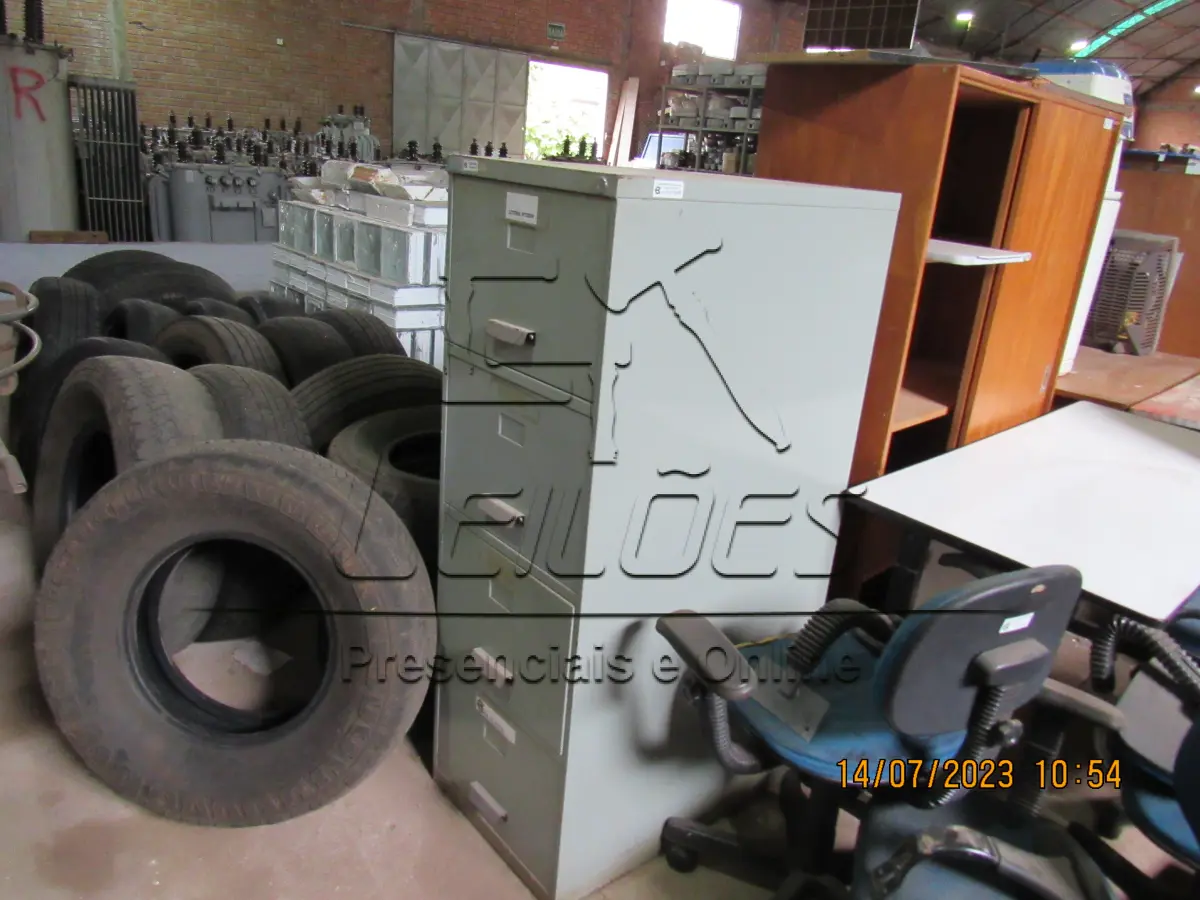 LOTE 005 - Bens diversos (03 mesa, 02 armários, 01 circulador de ar, 06 cadeira, 04 monitores para computador, 01 bebedouro, 01 motor movimentador portão, 02 suportes de cancelas e 366 tijolos de vidro)