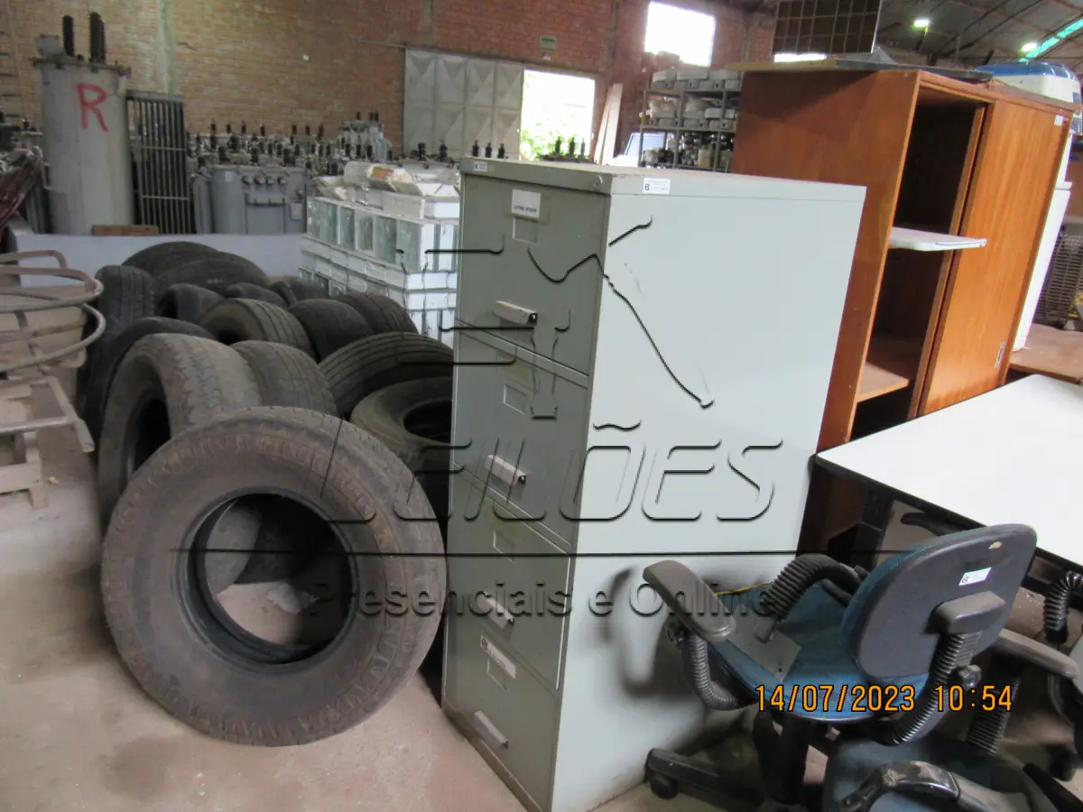 LOTE 005 - Bens diversos (03 mesa, 02 armários, 01 circulador de ar, 06 cadeira, 04 monitores para computador, 01 bebedouro, 01 motor movimentador portão, 02 suportes de cancelas e 366 tijolos de vidro)
