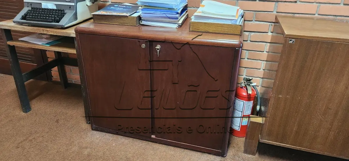 LOTE 009 - Mesa de madeira para escritório, com 06 gavetas e tampo de vidro. Acompanha 01 cadeira giratória, 02 cadeiras fixas, 02 armários e mesinha de apoio