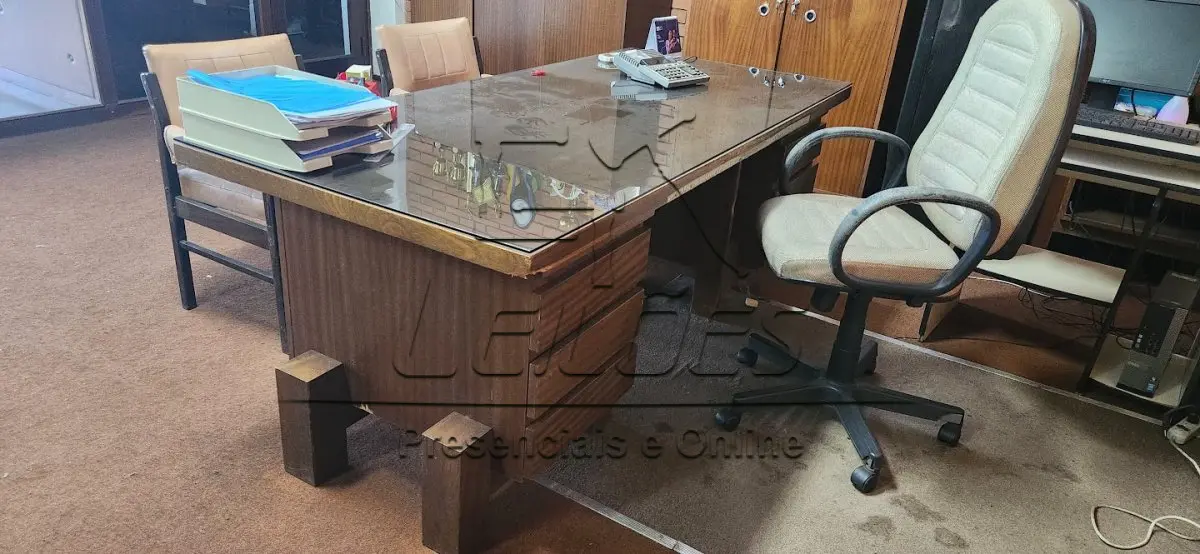 LOTE 009 - Mesa de madeira para escritório, com 06 gavetas e tampo de vidro. Acompanha 01 cadeira giratória, 02 cadeiras fixas, 02 armários e mesinha de apoio